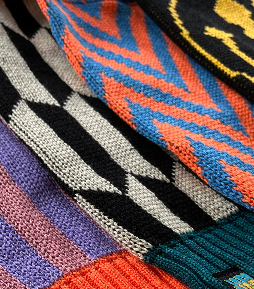 Suéteres Japi Japi apilados mostrando distintos colores y estampados